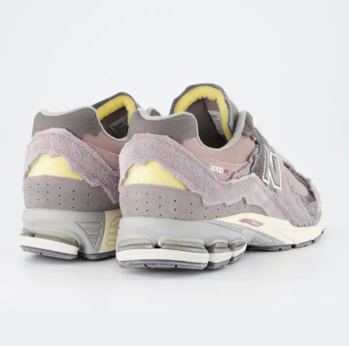 Vista trasera New Balance 2002R Protection Pack lila con amortiguación N-ergy y suela crema.