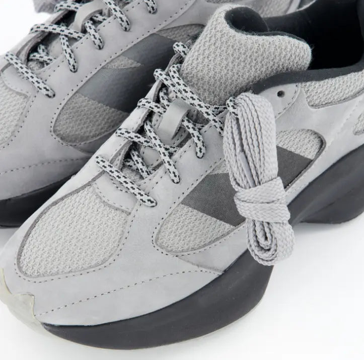 Detalle de materiales New Balance WRPD Runner con ante gris, malla técnica y cordones jaspeados.