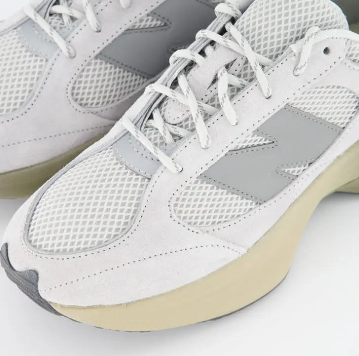 Primer plano de New Balance WRPD Runner con paneles de ante gris y malla técnica de punto abierto.