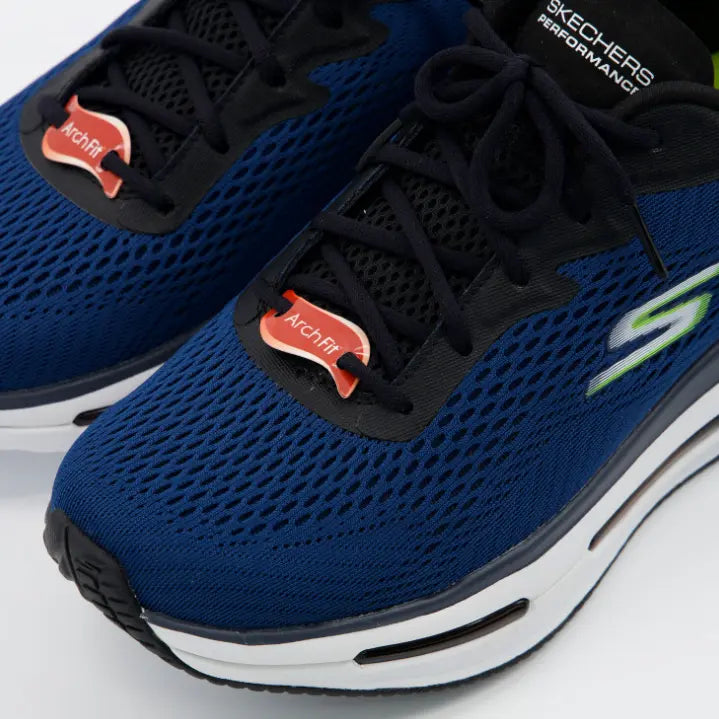 Primer plano de la malla azul y etiquetas rojas "Arch Fit" en los cordones de las zapatillas Skechers Performance, destacando el soporte certificado.