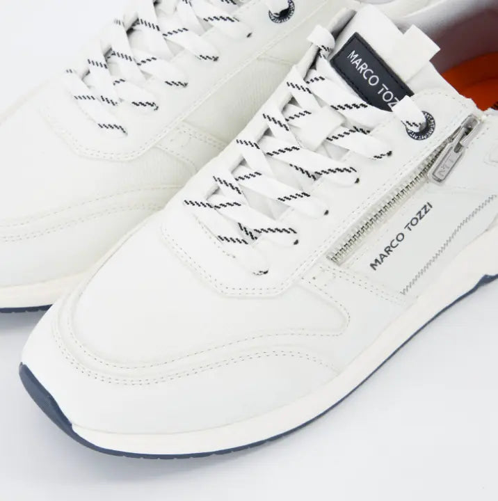 Primer plano de zapatillas Marco Tozzi blancas con combinación de texturas sintéticas y malla transpirable.