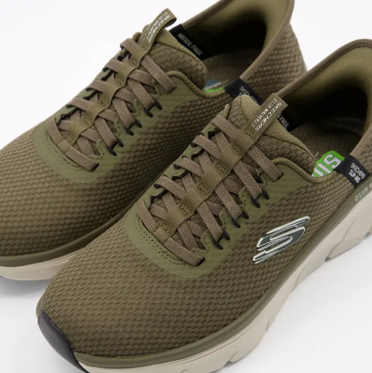 Primer plano de la parte delantera de las zapatillas Skechers D'Lux Walker 2.0 Slip-ins verdes, mostrando la textura de la malla de ingeniería, los cordones elásticos fijos y la suela beige.